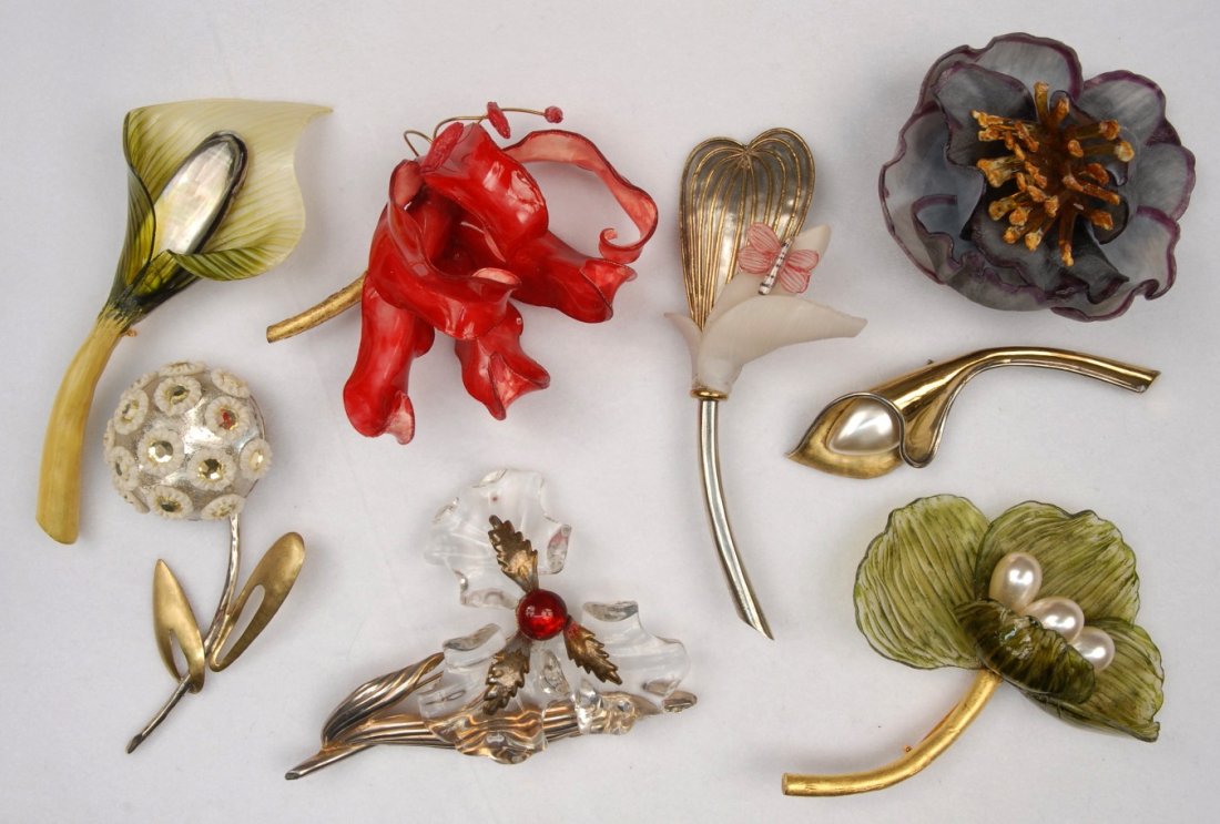 FABRICE of PARIS BROOCHES, 1964 - MODERN.: Seven floral brooches in various materials including plastic, mother of pearl, metal, faux pearls and glass. All signed "Fabrice Paris". Together with one similar but unsigned brooch with clear plasti