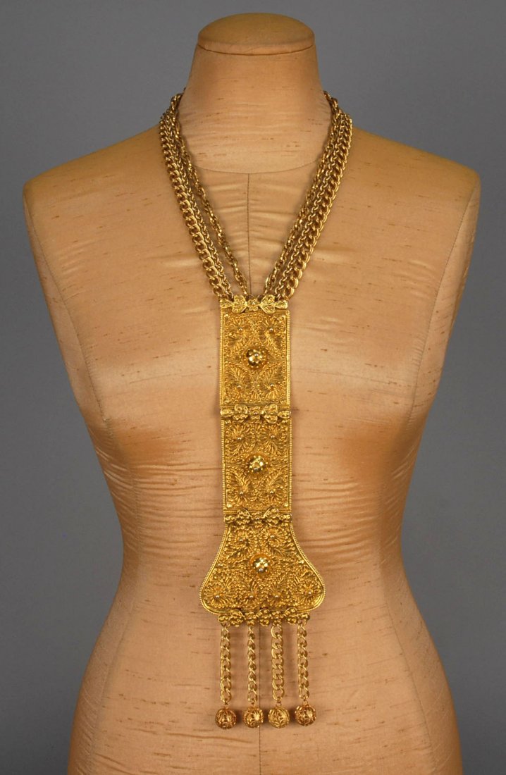 JUDITH LEIBER PENDANT NECKLACE.: Oversized gilt metal three-piece hinged pendant having relief decoration of domes and scrolls with ball tassels, all suspended from three variform link chains. Signed. Pendant 3 3/8 x 12, overall L-22