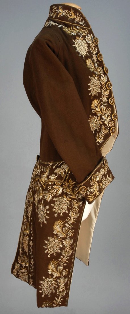GENTS FRENCH METALLIC EMBROIDERED WOOL COAT, 1774 -: Brown wool with stand collar, deep cuff, faux pockets with scalloped flap and back pleats, extensively decorated with white silk and silver and gold metallic thread with sequins and blue paillettes, e