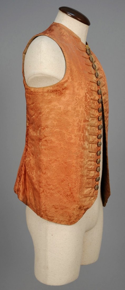 GENTS SILK DAMASK WAISTCOAT, 17th-18th C.: Salmon pink silk with an elaborate Renaissance style pattern front and back, tiny Mandarin collar, silk covered buttons decorated with metallic embroidery and central sequin, small length of metallic 