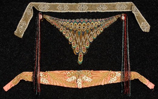 THREE LADIES BEADED BELTS, EARLY 20th C.: One gold mesh triangle decorated with polychrome bugle beads and rhinestones, having long beaded fringe at corners, triangle 10 x 20, (some fringe detached but retained). One pink silk with pearls and