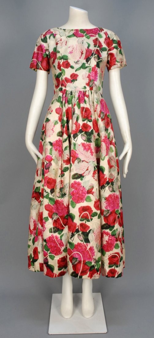UNLABELED WARP PRINTED and BROCADE SILK DRESS, MID 20th: Cream with green and fuchsia floral print and white brocade foliage, short sleeve with boat neck, square open back and long full skirt. B-34, W-26, L-51. (Fabric frayed near top of zipper, tiny spot o