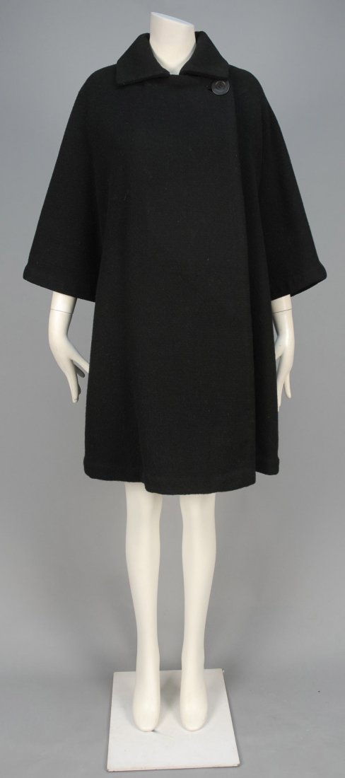 MADAME GRES WOOL SWING COAT, 1950s.: Black with squared collar, double breast with single button, 3/4 sleeve cut as single piece with front and back, black and white houndstooth lining with single inside patch pocket. Labeled. L-36. Exce