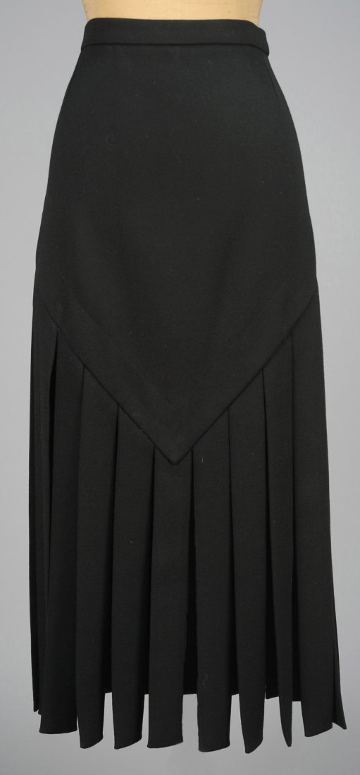 PIERRE CARDIN WOOL ÒCAR WASHÓ SKIRT, 1960s.: Black crepe fitted through the hip having long fabric strips extending from a "V" shaped hem. Labeled. W-28, H-36, L-35 1/2. Excellent.