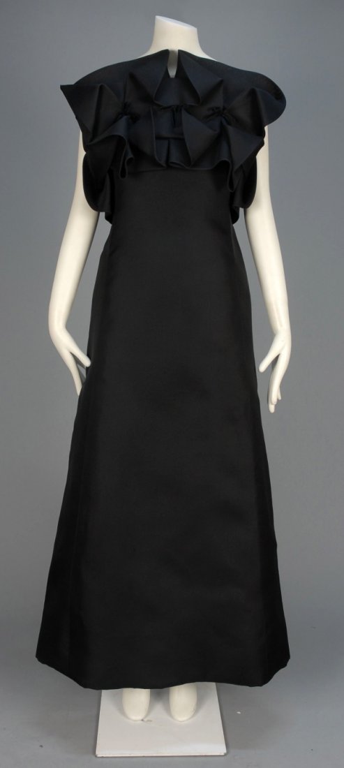 PIERRE CARDIN ORAGAMI EVENING DRESS, c. 1976.: Sleeveless black silk gazar with spaghetti strap, empire bodice top folded into a geometric pattern held in place by velvet bows, A-line skirt. Labeled. B-34, W-26, H-44, L-56. Excellent. LACMA.
