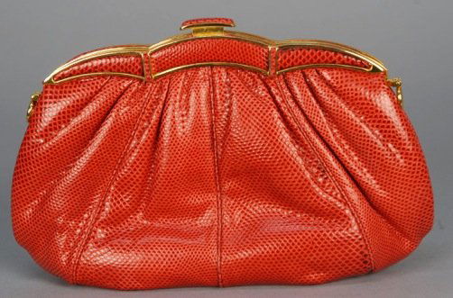 JUDITH LEIBER LIZARD CLUTCH.: Red skin with hinged brass frame having scalloped top and plunger clasp, red satin interior with open pocket and coin purse, optional hinged shoulder strap. Brass label. 8 1/2 x 5 1/2, strap 20 inch d