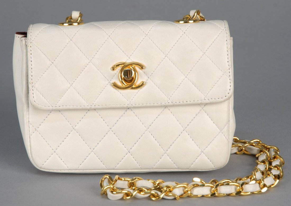 CHANEL QUILTED LEATHER MINI CROSS BODY BAG.: Bone lambskin with leather strung chain handle and logo clasp, labeled, logo hardware, marked clasp. 5 1/2 x 4 x 2. Includes dust bag. (Tiny mark on back, minor wear to corners of flap) very good.
