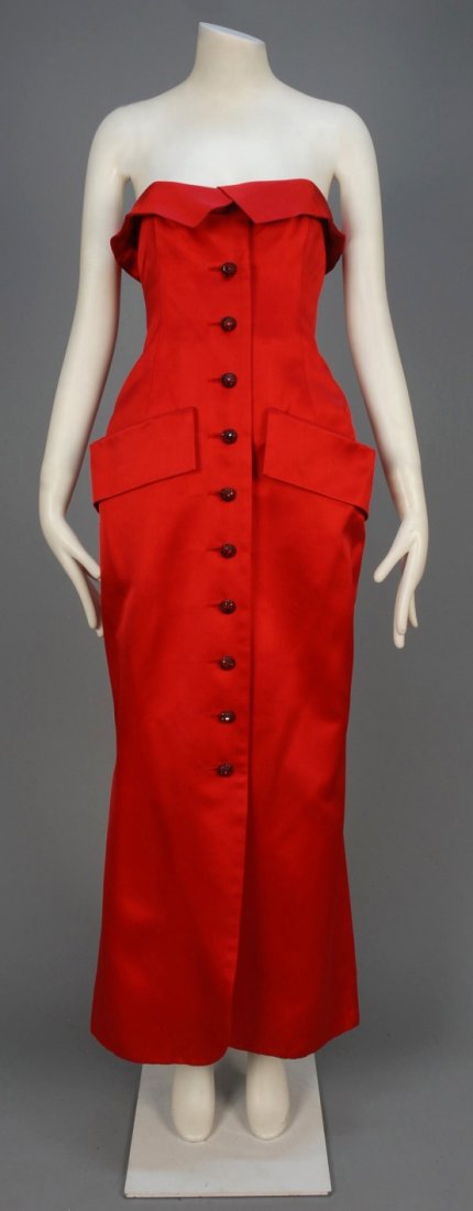 SAINT LAURENT RIVE GAUCHE STRAPLESS EVENING GOWN,: Red silk satin having fold over bodice top, button front with red jeweled buttons and pockets with deep flap, interior boned corset. Labeled. B-33, W-28, H-40, L-48. (Missing top button hidden beneath
