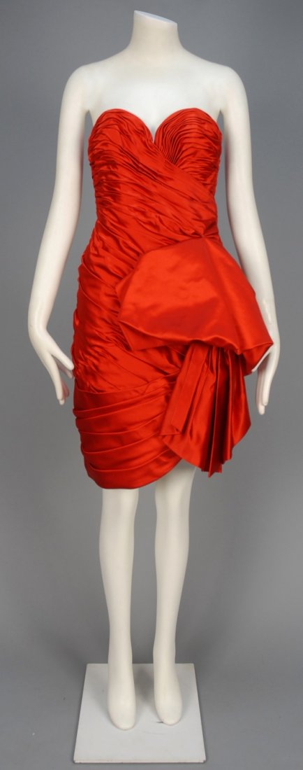VICKY TIEL PARIS STRAPLESS SATIN COCKTAIL DRESS.: Red silk short sheath having boned sweetheart bodice with crossed ruching, huge side bow detail, pleated swag to lower skirt. "Couture" label. B-34, W-24, H-36, L-32. Excellent.