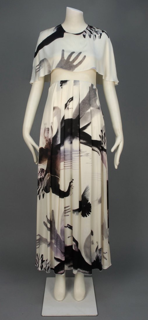 SONIA RYKIEL GRAPHIC PRINT MAXI DRESS.: White silk having print of birds and figures in shades of aubergine, capelet top over sleeveless mesh bodice, curved waistline and pleated full skirt. Labeled. B-34, W-30, L-54. Excellent.