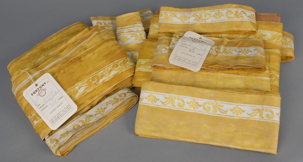 LARGE LOT of FORTUNY OLIMPIA YELLOW BORDER FABRIC,: Mottled cotton with white band having stenciled design, sixteen pieces 3 1/2 - 4 1/4 inches wide, approximately 106 yards total. Together with assorted narrower lengths in the same pattern. Some marke