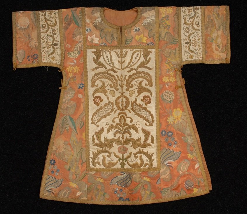 BROCADE and EMBROIDERED CHASUBLE, 18th C.: Probably Italian having bizarre silk patchwork construction with large embroidered panels on front and back of sleeves. 50 x 42. (Abrasion and early mending on two center embroidered panels) otherwise