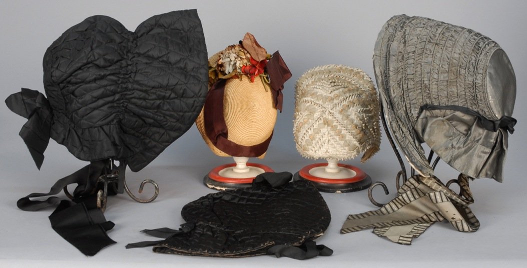FIVE HATS and BONNETS, 19th C.: Two straw: One grey 1880s, one natural 1860s. Two black quilted winter bonnets 1880s. One grey silk bonnet 1840s. Good-excellent.