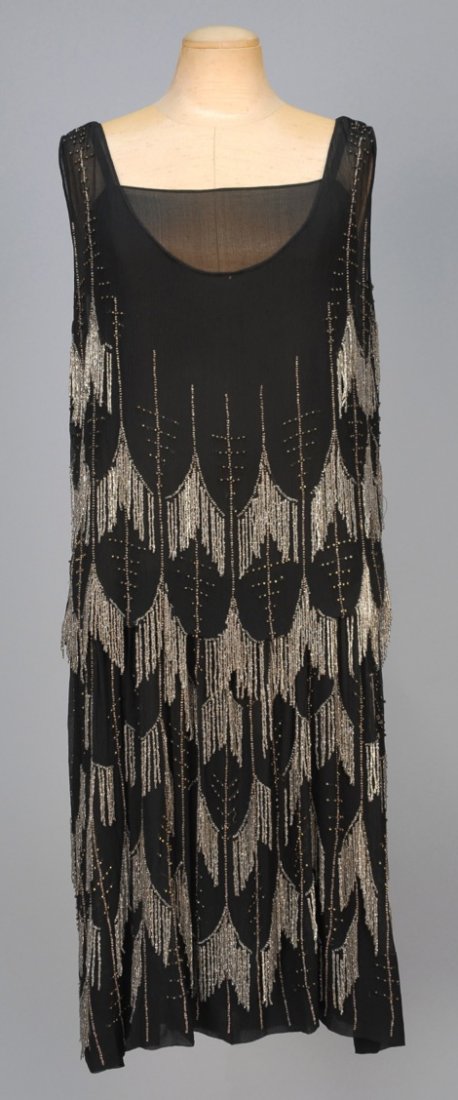 ADAIR PARIS CHIFFON FLAPPER DRESS with BEADED FRINGE,: Black silk with crystal fringe forming an allover scallop pattern with vertical bands of clear and silver beads, blouson top and chiffon underdress. Labeled. B-40, L-42. (Tear under one arm, bead loss
