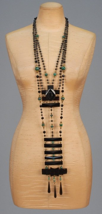 JOHN TRUSCOTT FORTUNY REVIVAL NECKLACE, 1975.: One of a kind necklace constructed from various beads including antique jet, jade green glass and malachite with black plastic ornaments, intended to be worn with a Delphos gown. L-30. (Small repair t