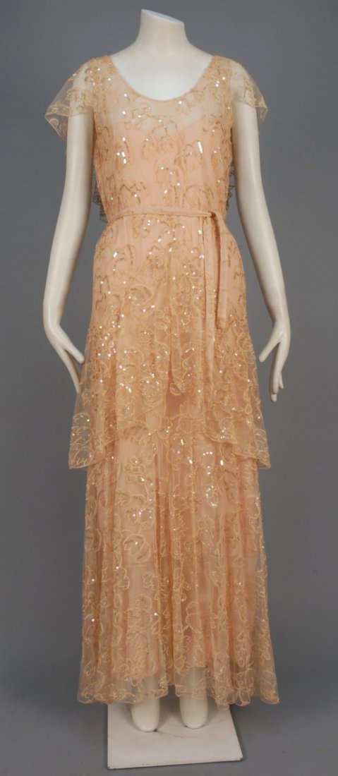 SUMMER GOWN with EMBROIDERY and SEQUINS, 1930s.: Peach tulle embroidered in a stylized leaf and berry pattern decorated with opalescent sequins having ruffled caplet and long peplum over flared skirt, self belt, attached chiffon underdress. B-40, W-
