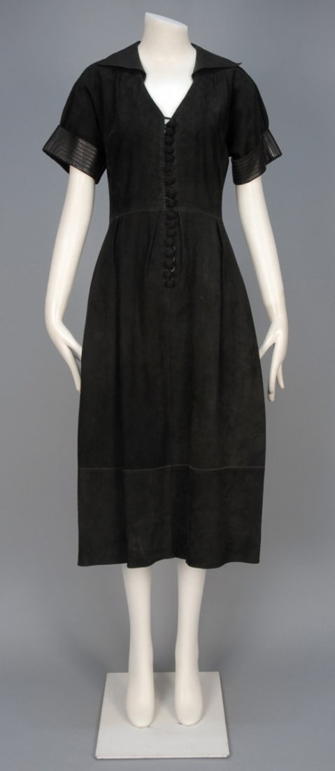 JEAN MUIR SUEDE DRESS with LEATHER TRIM, c. 1970.: Black day dress having spread collar and short sleeve cuffed in topstitched leather, crocheted button and self loop closure and A-line skirt with side seam pockets. Labeled. B-36, W-30, H-44, L-48. Ex