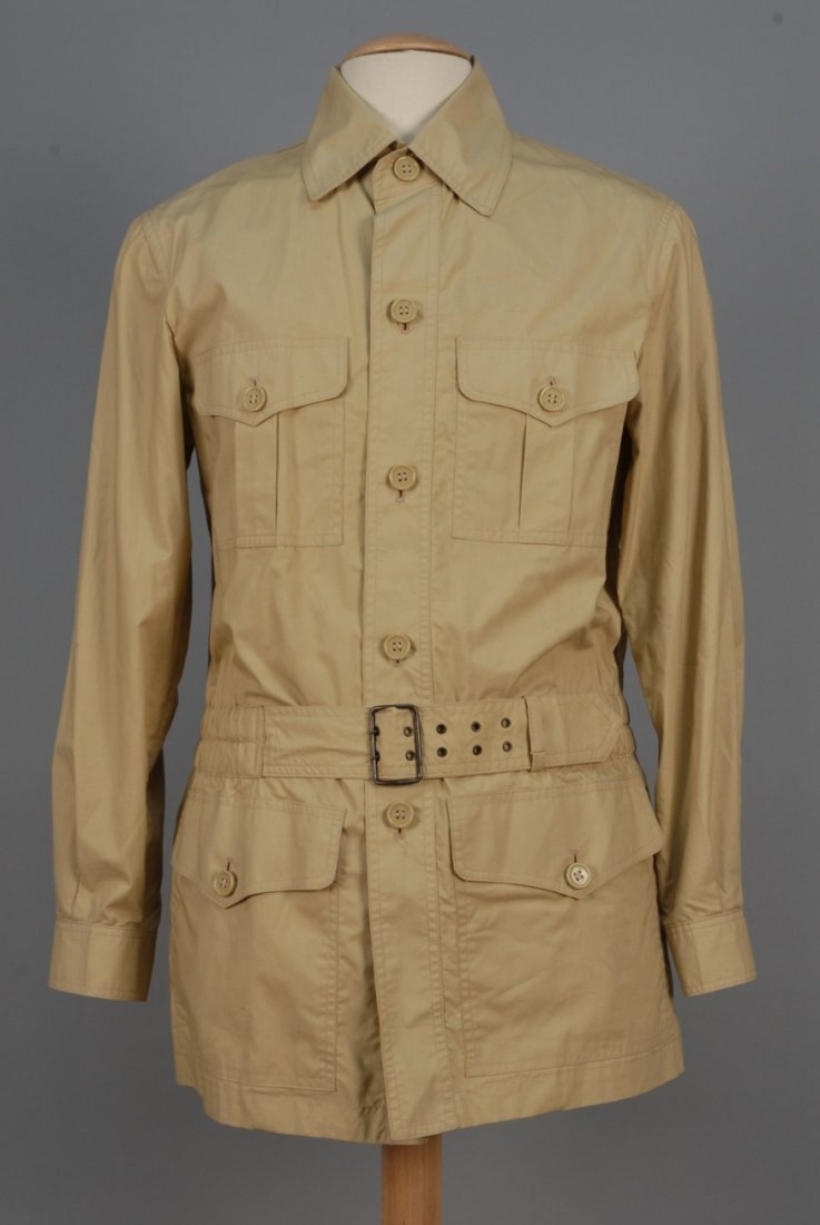 MANS YVES SAINT LAURENT SAFARI JACKET, 1970s.: Khaki cotton having four button-flap pockets, elasticized waist with self belt. Ch-40, L-31 1/2. Labeled. (Lightly soiled) otherwise excellent.