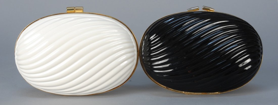 TWO WALBORG CAPSULE CLUTCHES.: Both hinged resin oval with wave pattern, brass trim and optional rope chain shoulder or crossbody strap: One black, one white. Labeled. 4 x 6 with 24 inch drop. (Black chain handle slightly oxidized)