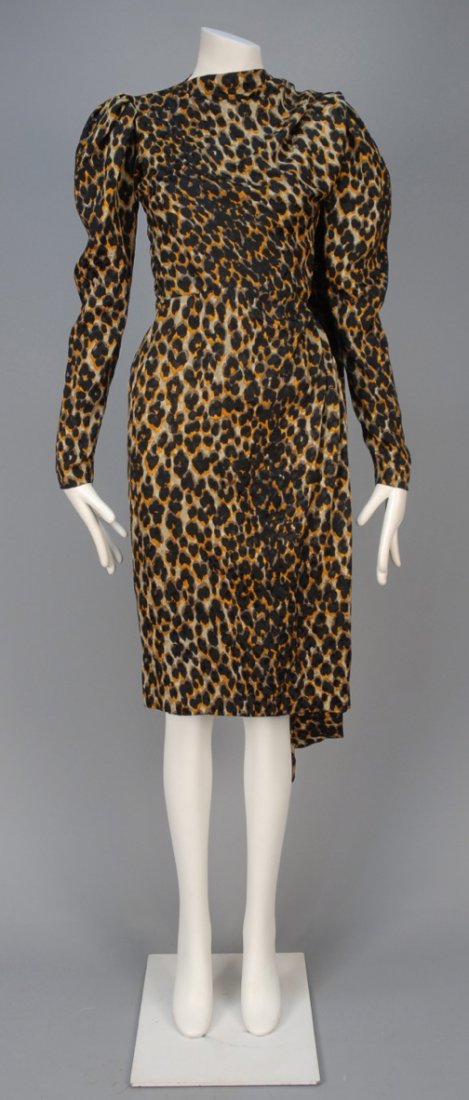 YVES SAINT LAURENT PARIS COUTURE SILK DAY DRESS,: Leopard printed silk jacquard wrapping across one shoulder with back drape, having zippered gigot sleeve and narrow skirt. Label "Yves Saint Laurent Paris" numbered 53378. B-36, W-23, H-36, L-41. Exce