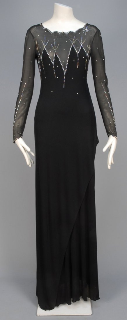 GIORGIO SANT ANGELO EVENING GOWN with RHINESTONES, c.: Black knit having sheer mesh bodice top and long sleeve, sawtooth boatneck with V-back, decorated with Aurora Borealis rhinestones, long skirt with side wrap, interior mesh bodysuit. Labeled. B-34, W-