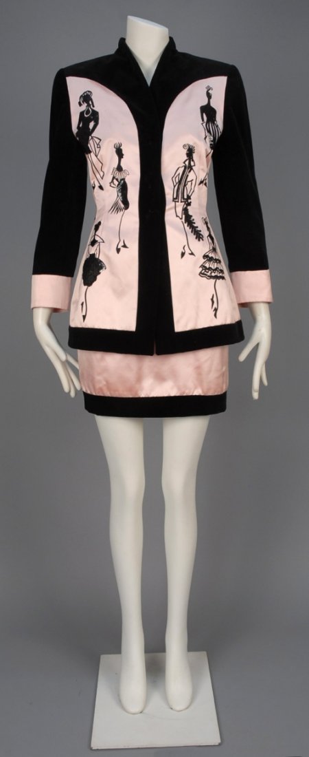 ESCADA CONVERSATIONAL SKIRT SUIT, 1980s.: Pale pink satin long jacket trimmed in black velveteen and decorated with embroidered and sequined fashion illustrations, matching mini skirt. Labeled. B-36, Sh-16, Slv-22 1/2, jacket L-29, W-23, H-35