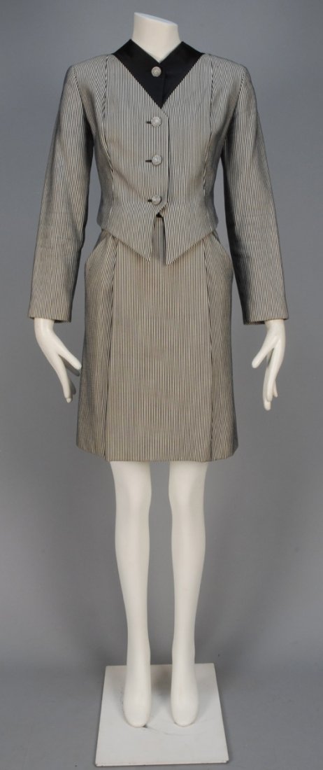 GEOFFREY BEENE STRIPED SKIRT SUIT, 1980s.: Black and white collarless jacket with V-shaped black satin neck insert, corded buttons and vest style hem, matching A-line skirt with box pleat and angled pockets. Labeled. B-36, Sh-16, Slv-22 1/2, W