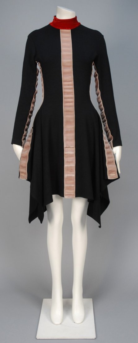 JEAN PAUL GAULTIER VELVET TRIMMED KNIT DRESS.: Long sleeve black knit decorated with rippling taupe velvet bands and red velvet mock turtleneck, square flared skirt falling into handkerchief points. Labeled. B-36, W-28, L-42. (Few small, faint spo