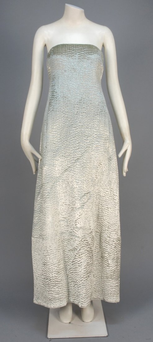 DEADSTOCK DONNA KAREN QUILTED VELVET EVENING GOWN.: Strapless platinum silk A-line puckered allover with stitches, hidden kangaroo pocket. Together with a Donna Karen sheer white ruched underdress (not pictured). Labeled. B-34, W-32, H-44, L-51. (Tiny 