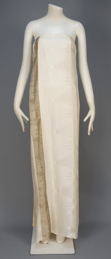 GIANFRANCO FERRE STRAPLESS EVENING GOWN.: Grecian inspired eggshell silk column having woven pattern and a narrow side panel of silk net embroidered with silver metallic thread, gunmetal bugle beads and crystal seed beads, floating back wrap 