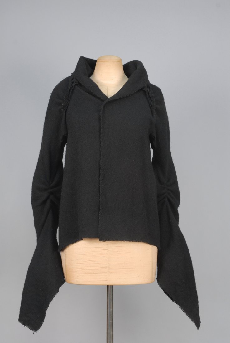 COMME de GARCONS WOOL JACKET.: Black with long pointed sleeve having gathers and open armhole, shawl collar, back with ruched details and hem slit, single hook & eye closure, unlined. Labeled. B-36, L-25. Excellent.