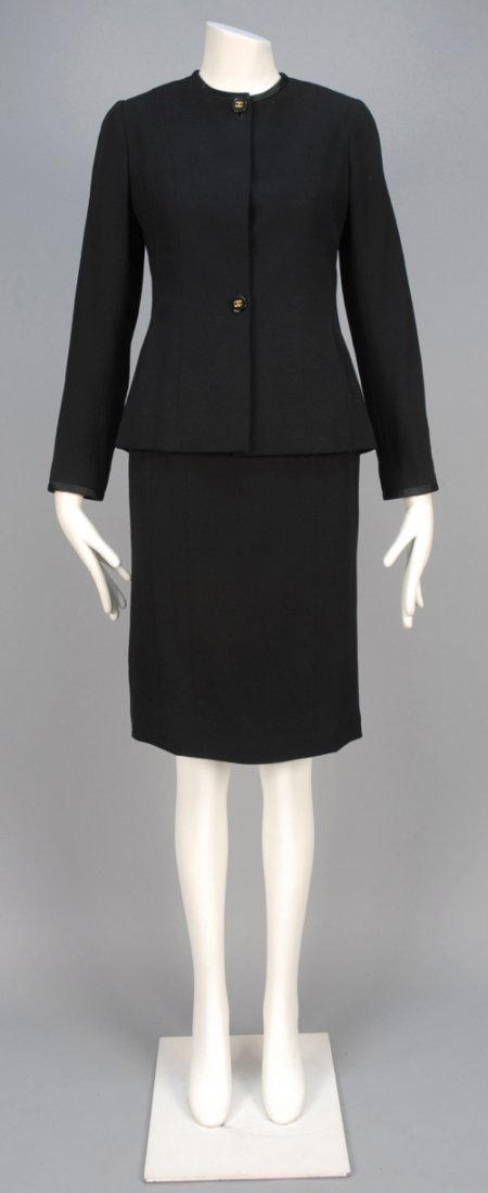 CHANEL WOOL SKIRT SUIT.: Black wool trimmed at jewel neck, cuff and side seams with satin bands, two logo buttons and four hidden buttons marked "Chanel Paris", five button cuff, matching narrow skirt and silk lining. Boutiqu