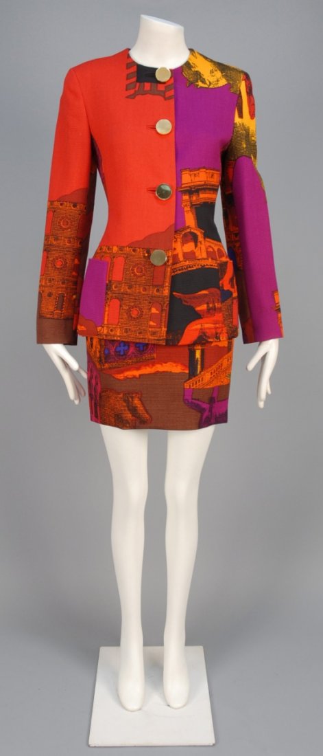 GENNY PRINTED WOOL SKIRT SUIT.: Ribbed wool printed with architectural elements in vibrant colors, collarless jacket with large gold tone buttons and patch pockets, matching mini skirt. Labeled. B-34, Sh-15, Slv-24, jacket L-27 1/2,