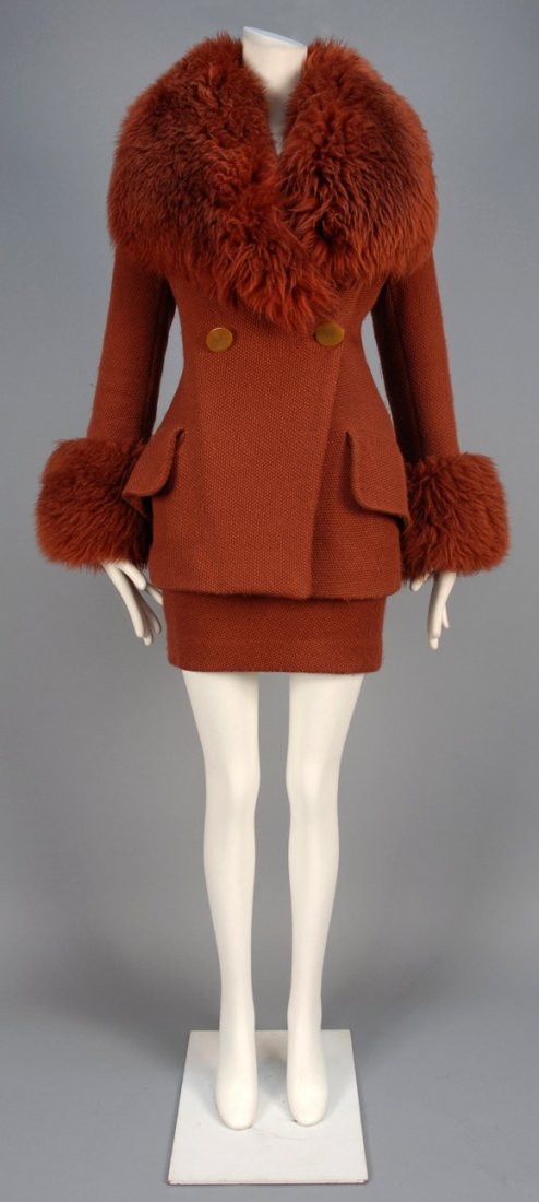 VIVIENNE WESTWOOD DOUBLE BREASTED WOOL SKIRT SUIT.: Russet wool in textured weave, the flared jacket having large faux fur collar and cuff, angled front with two oval logo buttons and large pocket flaps, matching miniskirt, fully lined in logo satin. R