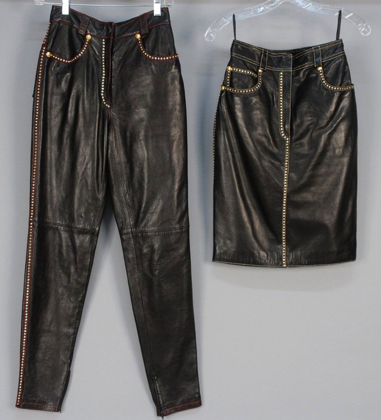 VERSACE STUDDED LEATHER SKIRT AND PANTS.: Both in black leather with five pocket styling having gold and silver studs, metallic topstitching, Medusa head logo accents and zipper pulls. Labeled. Skirt W24/H35/L22Pants W25/H36/Inseam 30. Excell