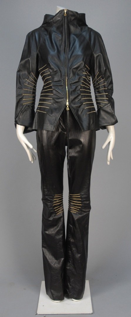 GIANFRANCO FERRE LEATHER PANTSUIT.: Black zip front jacket with raglan sleeve, wide funnel collar and split turn-back cuff decorated with a series of stitched slits, matching flared trousers with zippered lower inseam. Labeled. B-36, ja