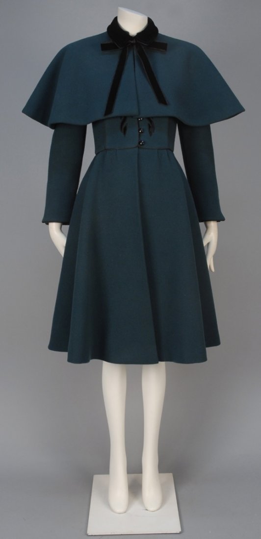 NINA RICCI WOOL COAT and CAPELET.: Forest green wool having stand collar, slightly gathered sleeve, set-in waist and full skirt decorated with black velvet floral applique and satin piping, faceted black button & loop closures, matchin