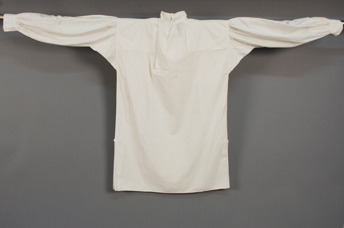 GENTS RUFFLED COTTON SHIRT, 19th C Hand sewn square-cut: GENTS RUFFLED COTTON SHIRT, 19th C Hand sewn square-cut fine white cotton having high stand collar with ruffle edged in lace, matching cuff with single high button, front open to hem with single butto