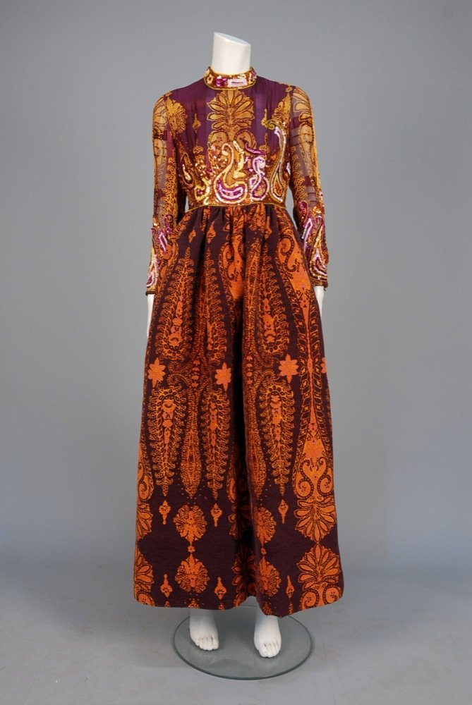 RONALD AMEY PRINTED and SEQUINED EVENING DRESS, 1970s.: RONALD AMEY PRINTED and SEQUINED EVENING DRESS, 1970s. Aubergine silk having bodice of chiffon with satin stripe and paisley print in gold and grey with colorful sequins and beads, sequined band colla