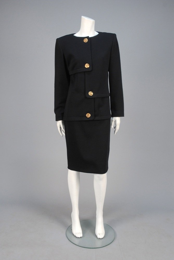 GALANOS WOOL KNIT DAY DRESS, 1980s. Long sleeve black: GALANOS WOOL KNIT DAY DRESS, 1980s. Long sleeve black tricot faux 2-piece having asymmetrical front panels with large gold tone buttons and topstitched details. Labeled. B-36, L-41 1/2. Excellent. MFA