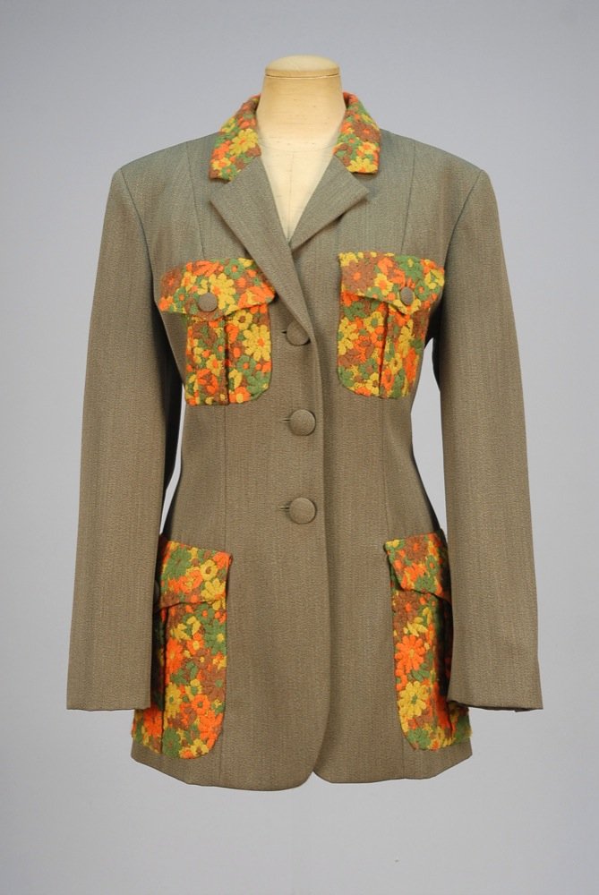 MOSCHINO EMBROIDERED WOOL BLAZER, 1980s. Grey-green: MOSCHINO EMBROIDERED WOOL BLAZER, 1980s. Grey-green gabardine having collar and four patch pockets with polychrome flower power embroidery, self buttons and satin lining. Couture! label. B-40, Sh-18,