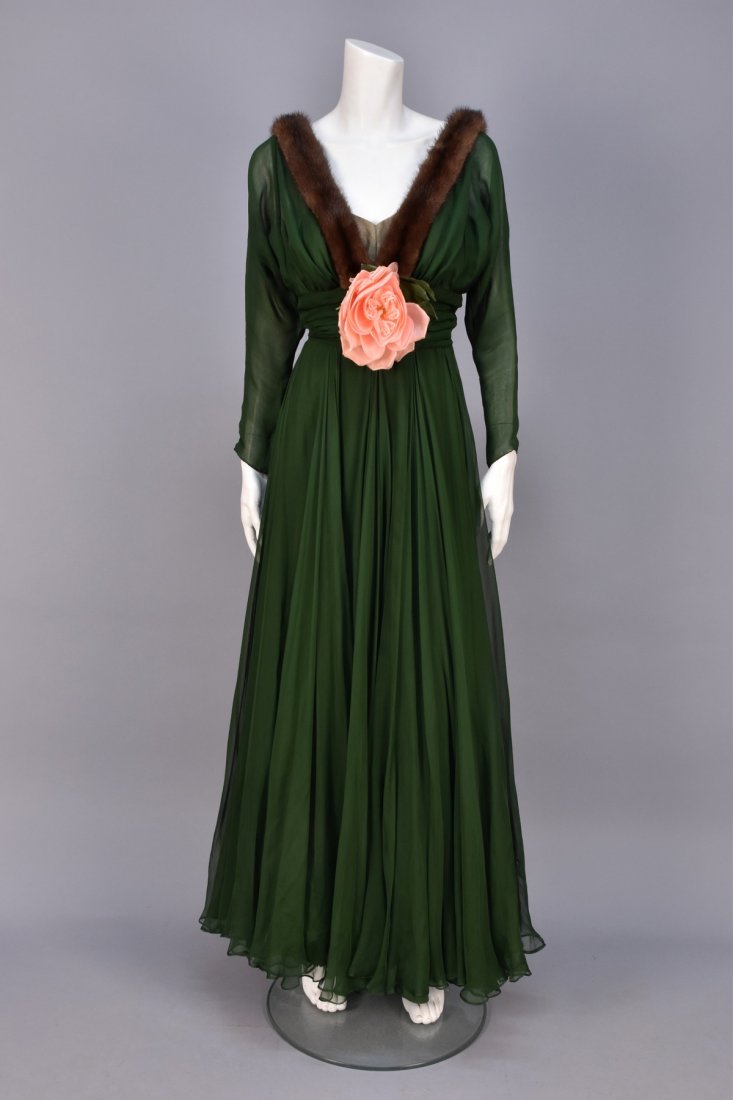 TRAINA-NORELL MINK TRIMMED CHIFFON GOWN, 1948.: Long sleeve green silk with V-neck and back edged in brown mink, ruched midriff band and full skirt, neck having chiffon over nude insert and large cloth flower. Labeled. B-34, W-24, L-59. (Few small 