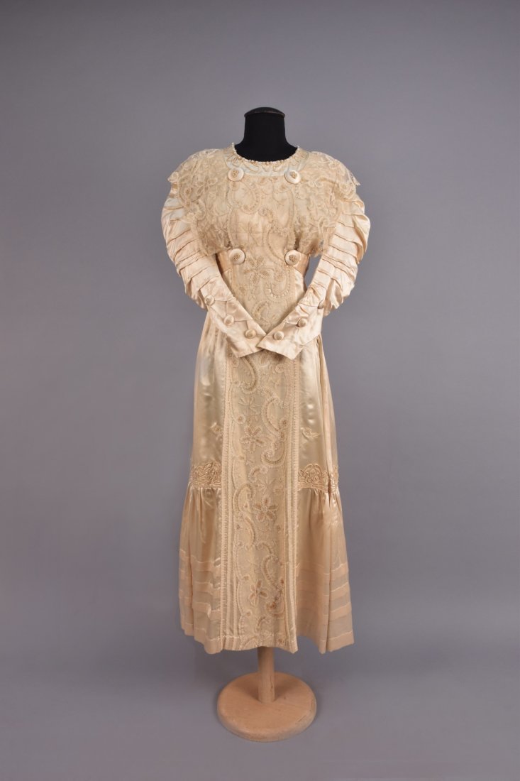 EDWARDIAN SATIN and LACE DRESS with SOUTACHE: One piece ivory satin having long sleeve with tucks, bodice trimmed at neckline with pearls, beads and soutache, lace overlay to front and back bodice and center skirt panel, pleated waistband with se