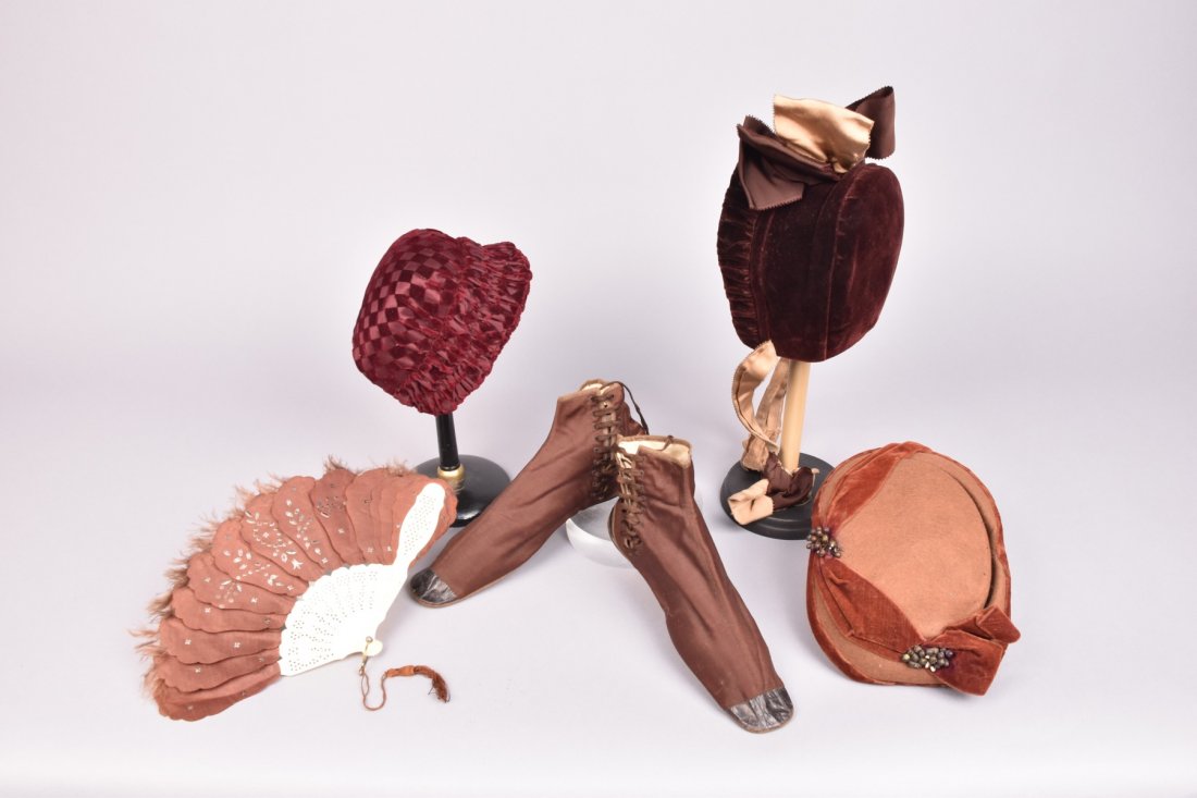 FIVE LADYS ACCESSORIES, MID 19th C: Brown prunella wool side-lacing boots with leather toe cap and lower quarter. Two velvet bonnets: One brown with grosgain ribbon trim, (ties damaged), one claret voided in a diamond pattern, (small se