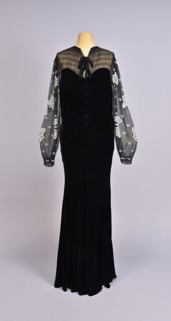 VELVET DRESS with BEADED SLEEVE, 1930s: Black with ruched voile, upper bodice having velvet ties above velvet bodice with self buttons, long voile sleeve decorated with butterflies worked in white beads and embroidery, bias-cut skirt. B-42,