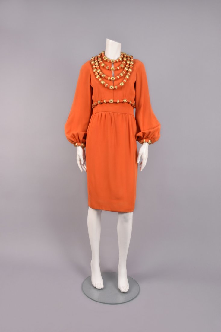 BOOTSY HEARSTâ€™S COCKTAIL DRESS with GOLD SWAGS, 1960s: Orange silk having three graduated self swags with heavy gold metal beads incised in a diamond pattern, long full sleeve gathered into beaded cuff, slit neckline, wide waistband with beaded swag, slig