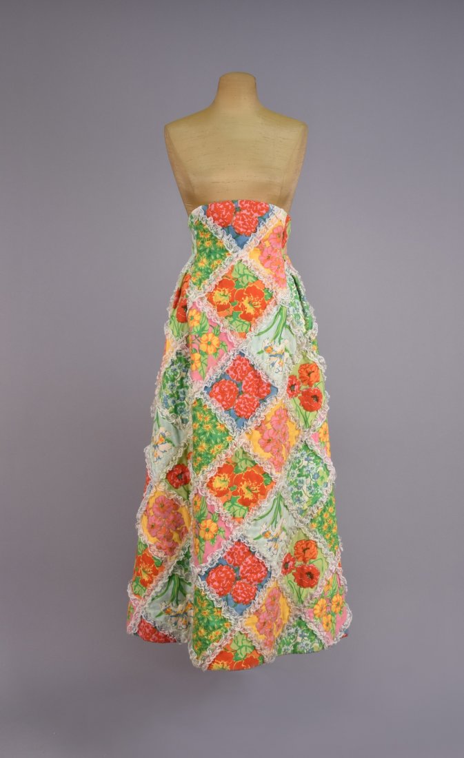 SCAASI FLORAL QUILTED MAXI SKIRT with LACE, 1970s.: Printed cotton high waisted A-line with lace-trimmed diamonds having various colorful florals with green stitching. Labeled. W-26, L-43. Excellent. GLC