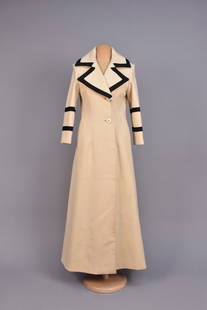 THEA PORTER WOOL MAXI COAT, c. 1970.: Cream with black passementerie trim to wide collar and lapel, a pair of bands to sleeve, nacre buttons, vertical welt pockets, back slit from waist to hem, black and white silk lining with whimsical b