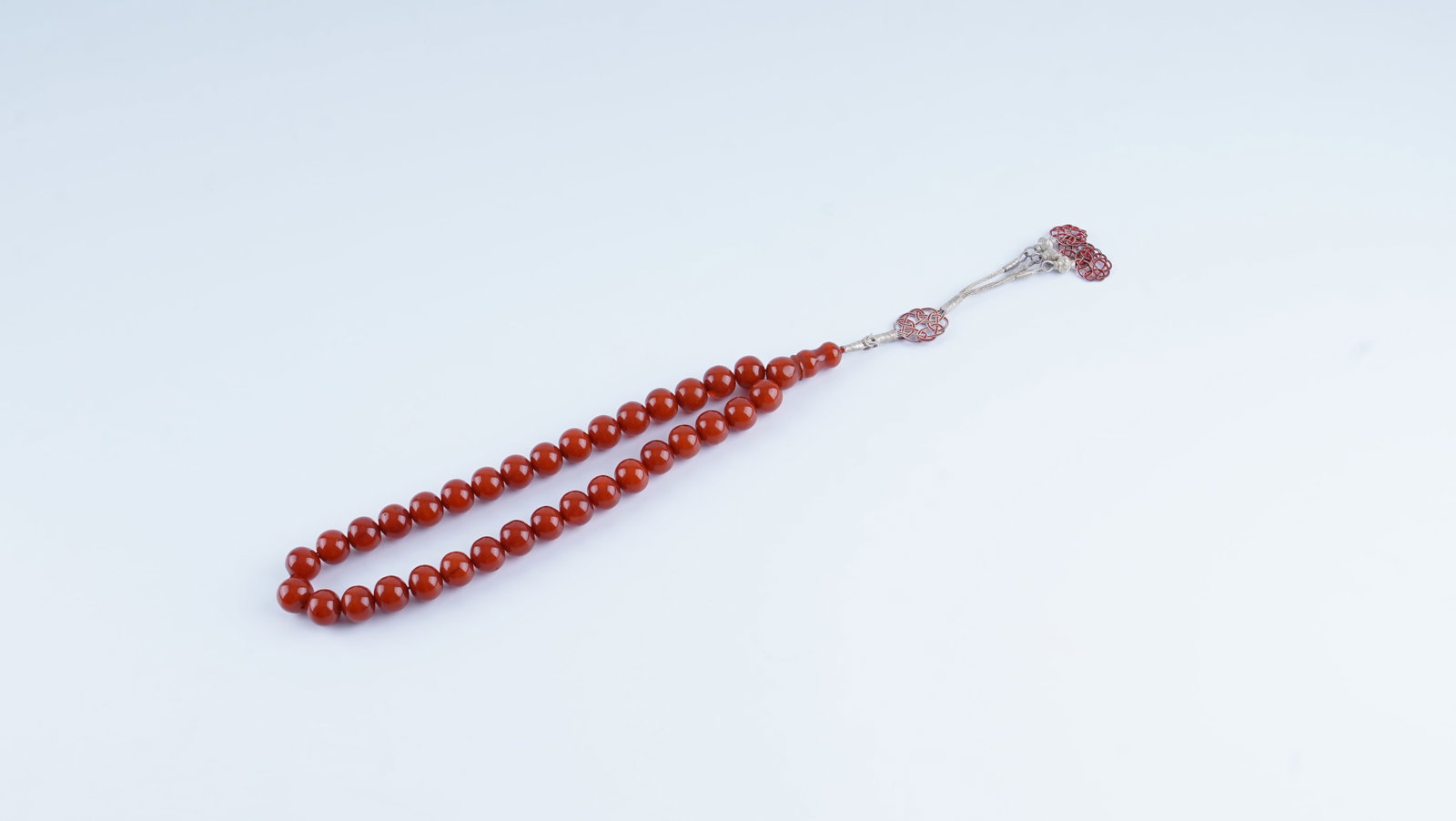 A STRAND OF OLD CHERRY AMBER (FATURAN) PRAYER BEADS (TESBIH), EARLY 20TH CENTURY (1 of 3)