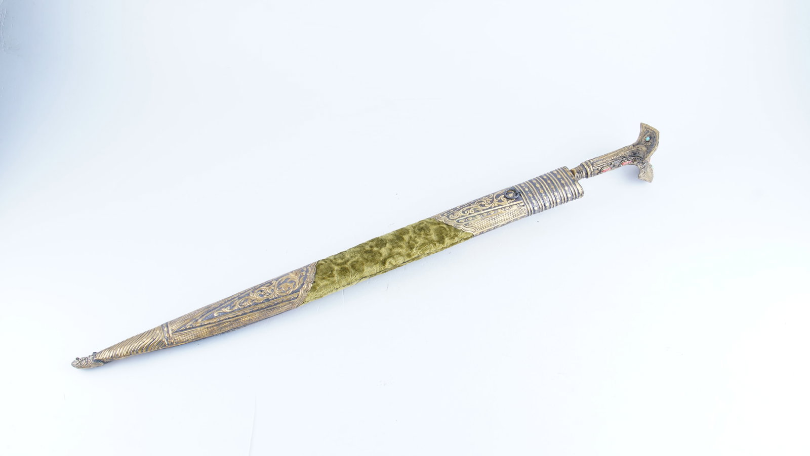 A RARE OTTOMAN YATAGHAN WITH CORAL AND TURQUOISE INLAID HILT AND DRAGON-HEAD SCABBARD MOUNT: A rare Ottoman yataghan, featuring a distinctive hilt inlaid with coral and turquoise, and a scabbard mounted with a stylized dragon-head terminal. The slightly curved blade follows the traditional ya